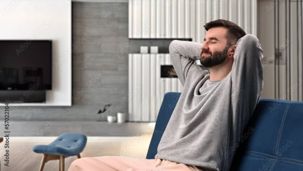Happy bearded man stress free relaxing with hands behind head closed eyes on couch at home apartment Happy bearded man stress free relaxing with hands behind head closed eyes on couch at home apartment