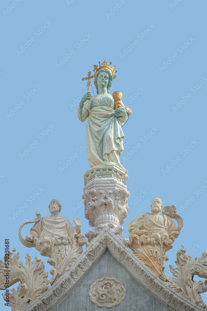 Cover page with ancient statue of Maria with cross and holy grail at the roof top decoration of Doge Palace in Venice, Italy, at blue sky background with copy space. Concept of architecture heritage