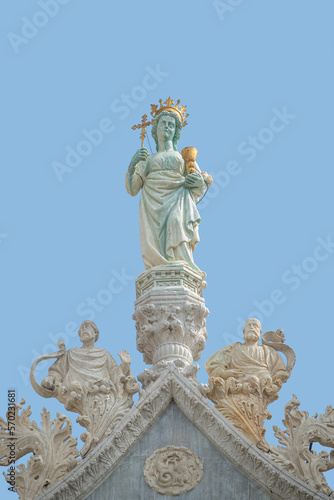 Cover page with ancient statue of Maria with cross and holy grail at the roof top decoration of Doge Palace in Venice, Italy, at blue sky background with copy space. Concept of architecture heritage