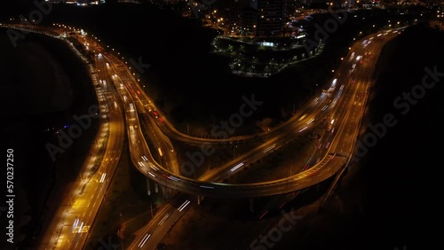 Drone hyperlapse of a coastal overpass that leads into an uphill road called 