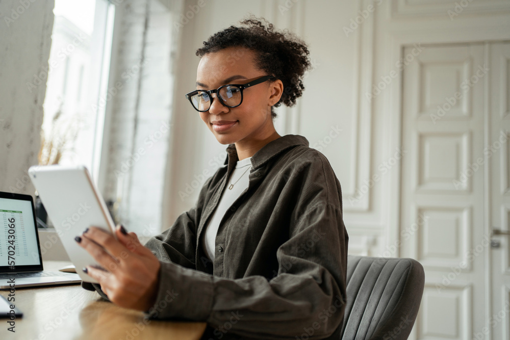 Office worker daily video work online. A young female freelance designer working in an office using a desktop computer. Office worker daily video work online. A young female freelance designer working in an office using a desktop computer.