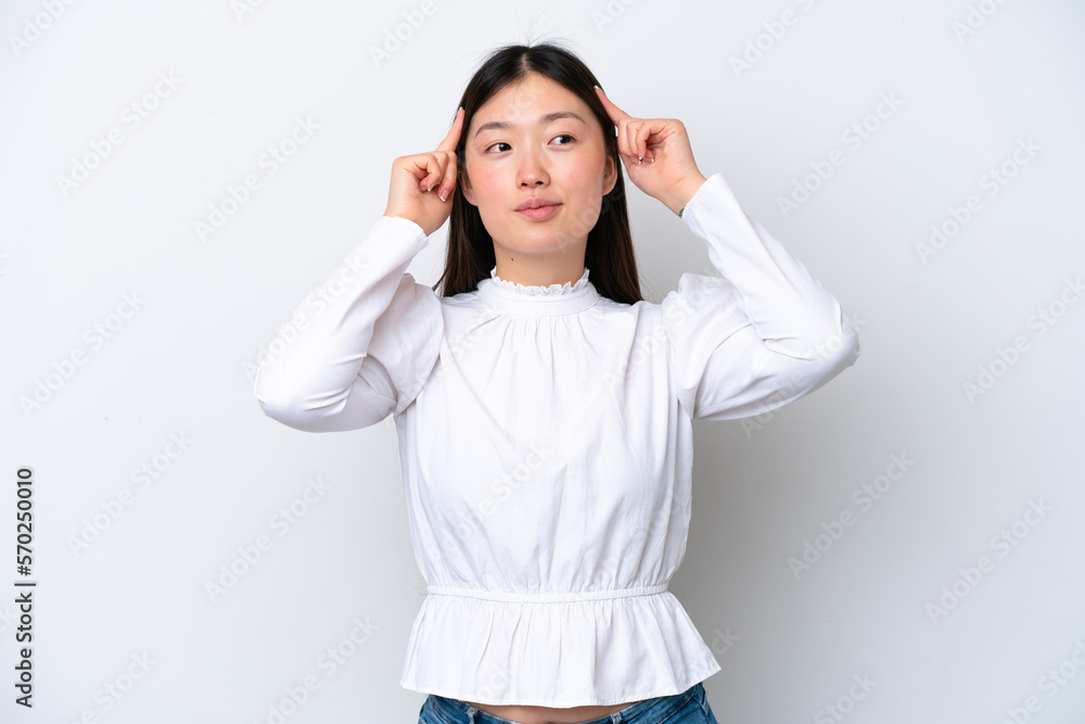 Young Chinese woman isolated on white background having doubts and thinking Young Chinese woman isolated on white background having doubts and thinking