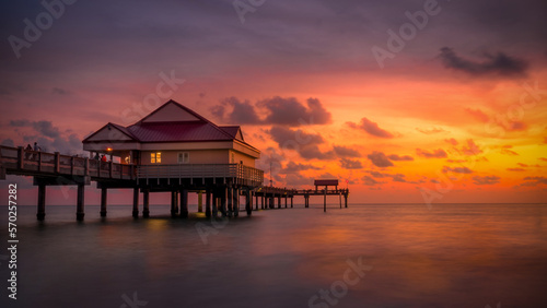 Sundown with the clouds and sky set on fire by the last rays of the sun with the ocean reflecting to colors of the sky