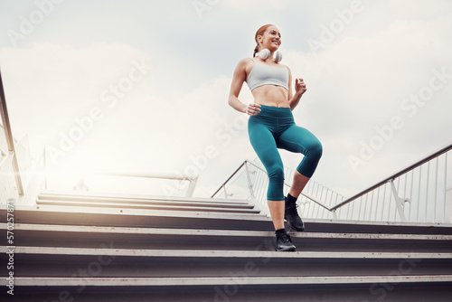 Fitness, woman and runner on stairs in the city for cardio exercise, training or healthy workout. Active female running and exercising on staircase for intense run or weight loss in an urban town