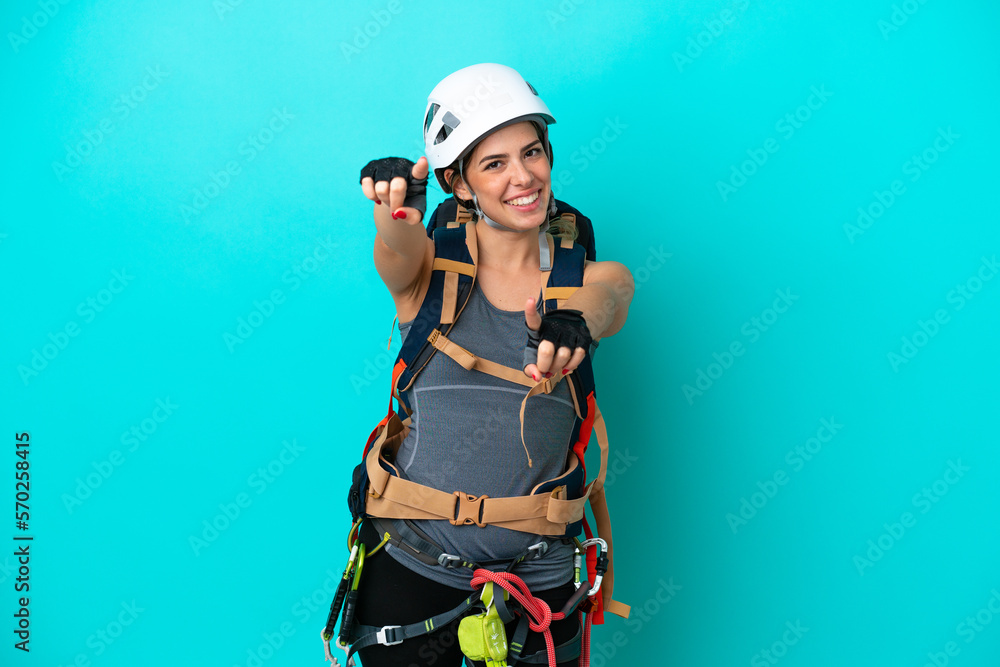Young Italian rock-climber woman isolated on blue background points finger at you while smiling Young Italian rock-climber woman isolated on blue background points finger at you while smiling