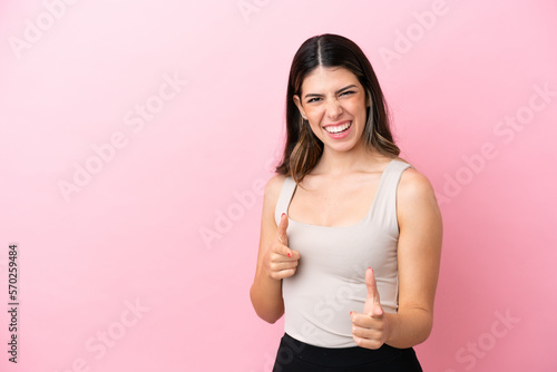 Young Italian woman isolated on pink background pointing to the front and smiling