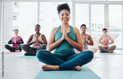 Black woman, yoga portrait and meditation with zen exercise for fitness, peace and wellness. Instructor and diversity group in gym class for prayer hands holistic workout, mental health and body