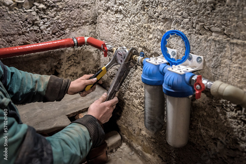 Plumber installing water equipment - meter, filter and pressure reducer photo