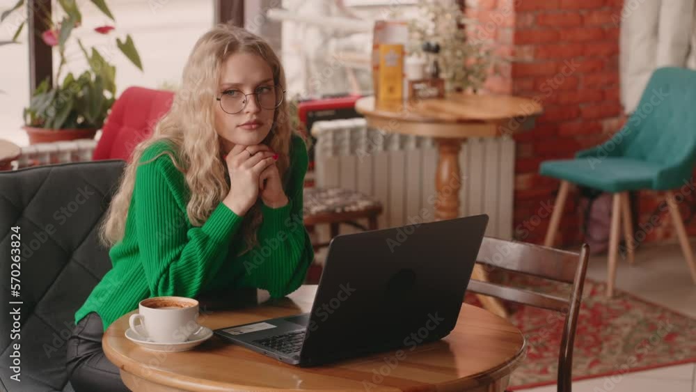 woman with laptop and cup of coffee sitting in cozy city cafe, working or studying, portrait woman with laptop and cup of coffee sitting in cozy city cafe, working or studying, portrait