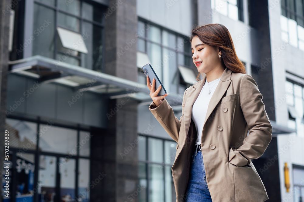 Businesswoman using her mobile phone and smiling Businesswoman using her mobile phone and smiling