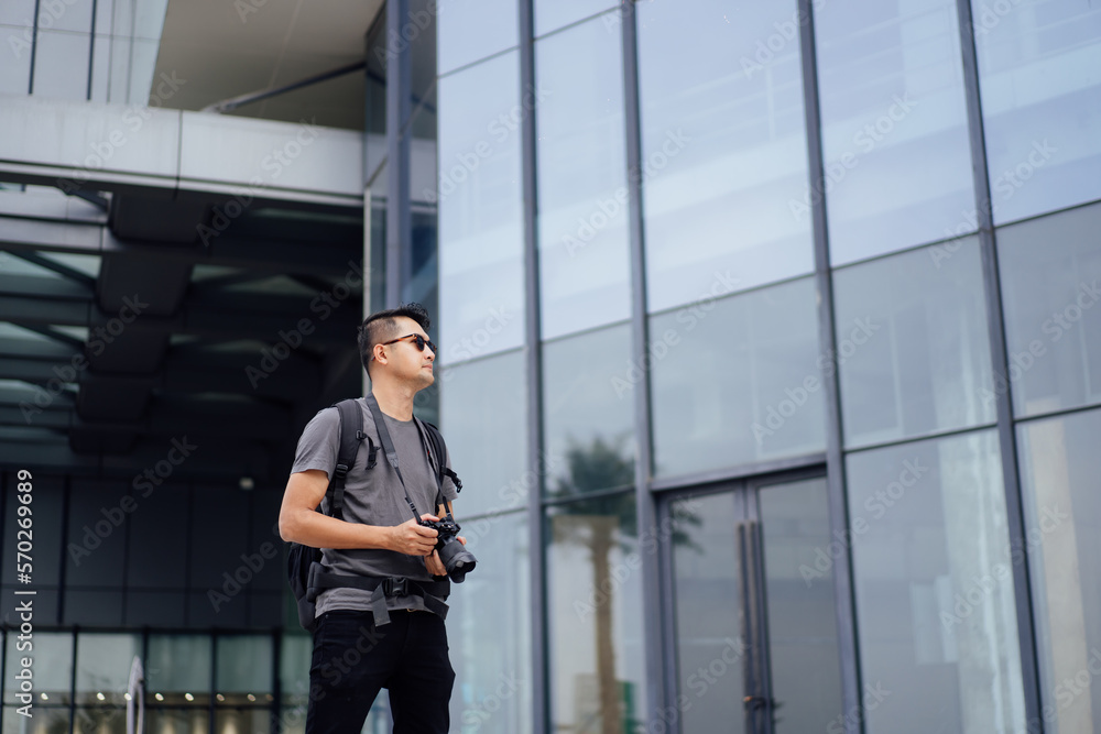 man taking photo during travel. Traveler man with camera and backpack outdoor. Young tourist male taking memory pic. Travel Asian man backpack taking man taking photo during travel. Traveler man with camera and backpack outdoor. Young tourist male taking memory pic. Travel Asian man backpack taking