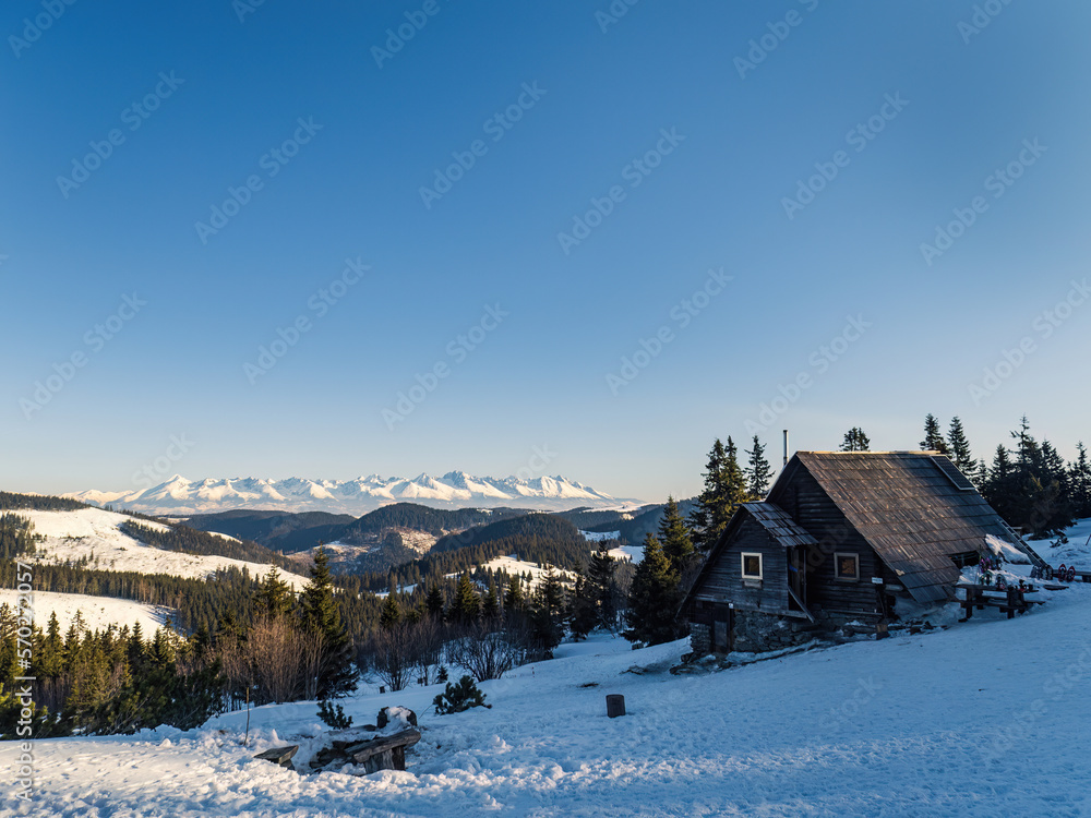 Mountain forest hut in the morning during winter snow