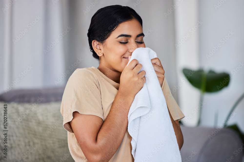House, cleaning and woman smelling laundry on a sofa, happy and relax