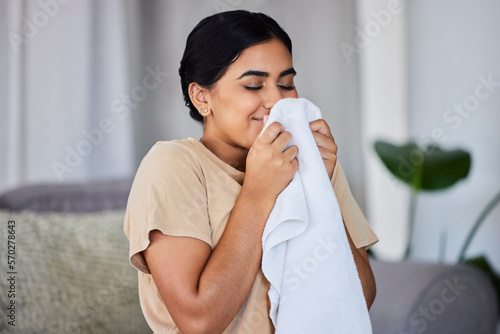 Photography House, cleaning and woman smelling laundry on a sofa, happy and relax alone in her home