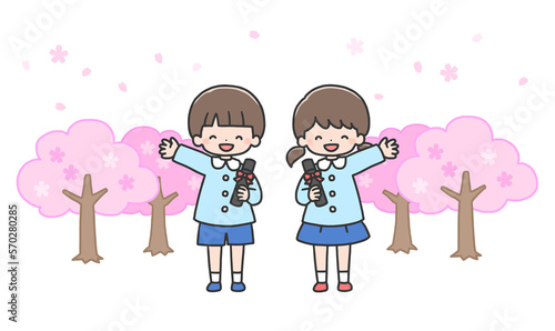 卒園式　桜の前に並んで立つ男の子と女の子