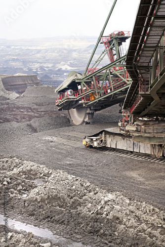 Bucket-wheel excavator during excavation at the surface mine. Huge excavator on open pit mine.