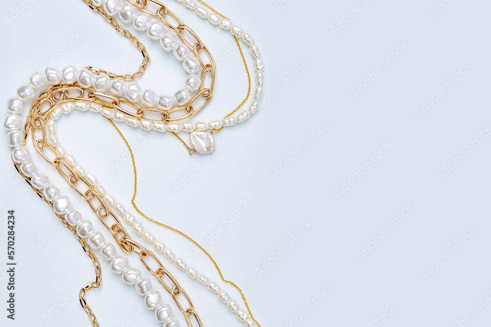 Fototapeta premium Trendy jewelry with chains and pearl necklace. Stylish golden bijouterie. Fashion accessories.