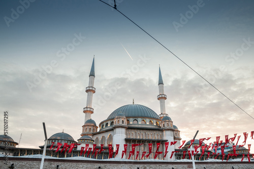 Main building of the Taksim Mosque, also called Taksim camii, with turkish flags. Taksim mosque is a muslim mosque located on taksim square, in Istanbul, by the gezi park and istiklal street. photo