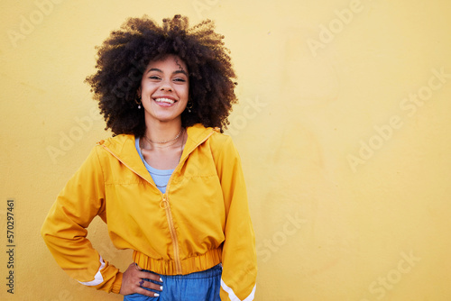 Portrait, fashion and mockup with an afro black woman in studio on a yellow background for style. Trendy, hair and mock up with an attractive young female posing alone on product placement space