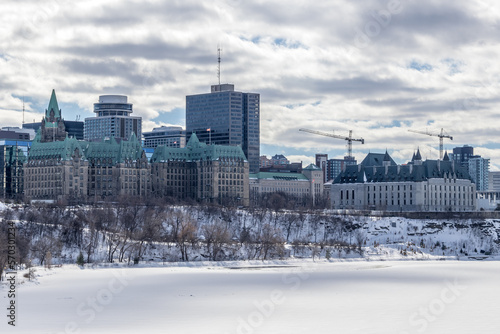 Having a walk through the Majors Hill Park in downtown Ottawa Canada with view to the historical buildings of the Canadian parliament and its surroundings at a cold but sunny day in winter.