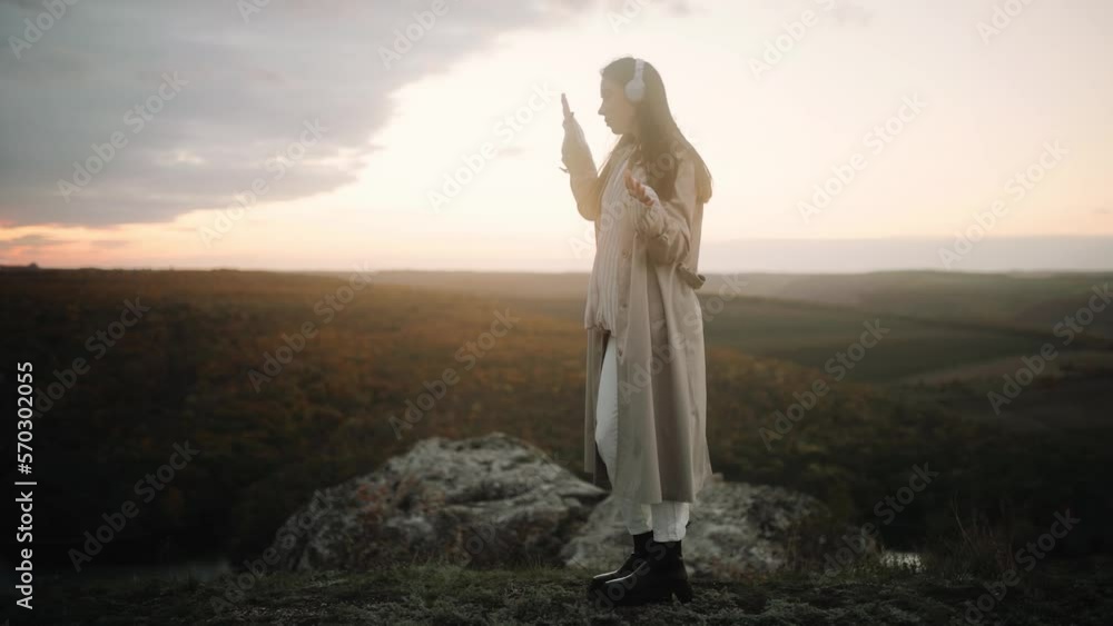 Young Beautiful Woman in Headphones Enjoying her Favorite Song during Incredible Sunset Young Beautiful Woman in Headphones Enjoying her Favorite Song during Incredible Sunset