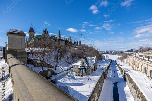 Having a walk on the Parliament Hill in downtown Ottawa Canada with view to the historical buildings of the Canadian parliament and its surroundings at a cold but sunny day in winter.