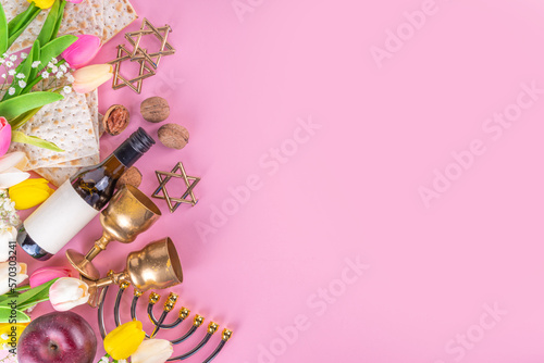 Passover, Pesah background. jewish Easter Passover spring holiday celebration, with accessories - menorah, matzo, spring flowers, wine bottle, gold wine glass, jewish david stars, copy space top view 