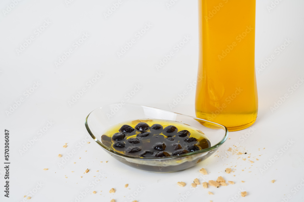Close up view of glass bottle of olive oil and pickled black olives isolated on white background. Close up view of glass bottle of olive oil and pickled black olives isolated on white background.