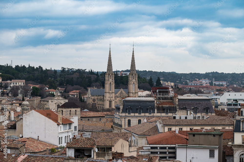 Nîmes, Occitanie, France - Skyline over old town with the twin towers of the Saint Baudilus Church