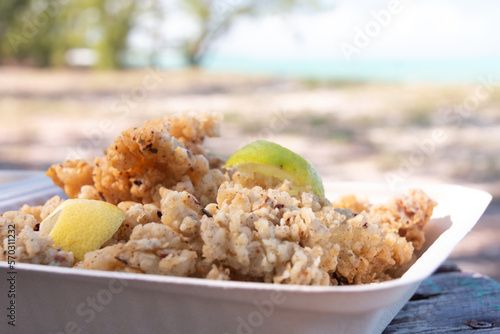 Closeup of a takeaway container filled with cracked conch, a tasty local seafood dish popular in the Caribbean, on Bambarra beach in Middle Caicos, Turks and Caicos Islands.