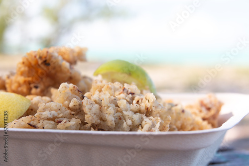 Closeup of a takeaway container filled with cracked conch, a tasty local seafood dish popular in the Caribbean, on Bambarra beach in Middle Caicos, Turks and Caicos Islands.