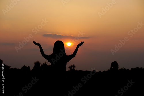 Fototapeta Naklejka Na Ścianę i Meble -  silhouette of human hand raised to make a wish, sunset background
