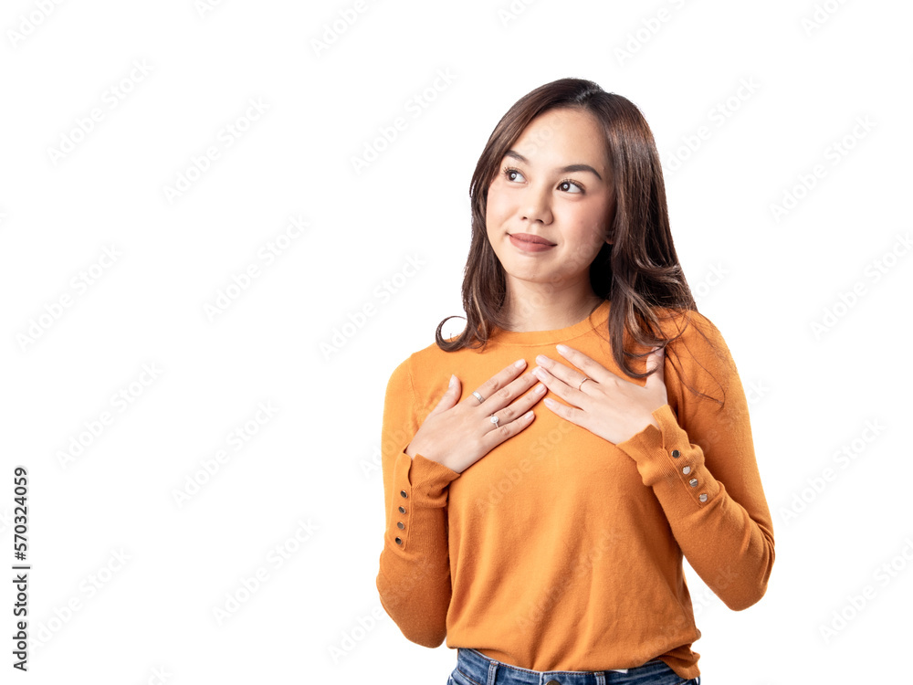 A portrait of a happy Asian Indonesian woman wearing an orange sweater, placing both hands on her chest, isolated on a white background A portrait of a happy Asian Indonesian woman wearing an orange sweater, placing both hands on her chest, isolated on a white background