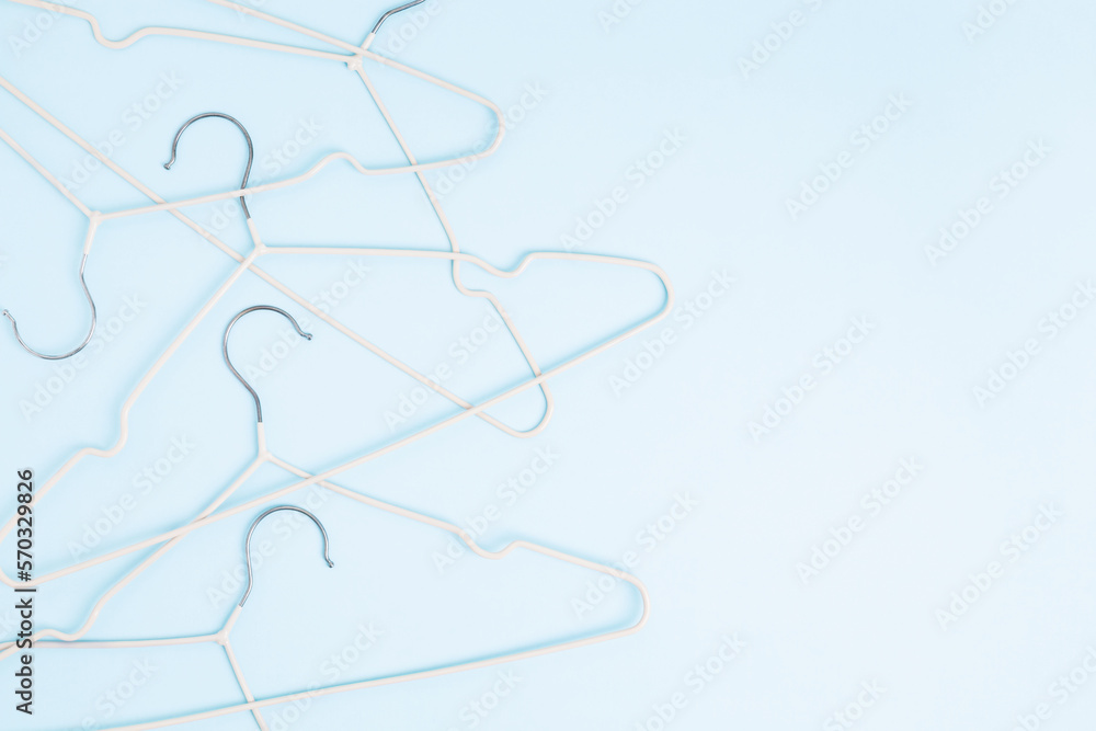 Creative flat lay hangers pastel blue background. Sale discount store promo shopping concept. Top view. Copy space Creative flat lay hangers pastel blue background. Sale discount store promo shopping concept. Top view. Copy space