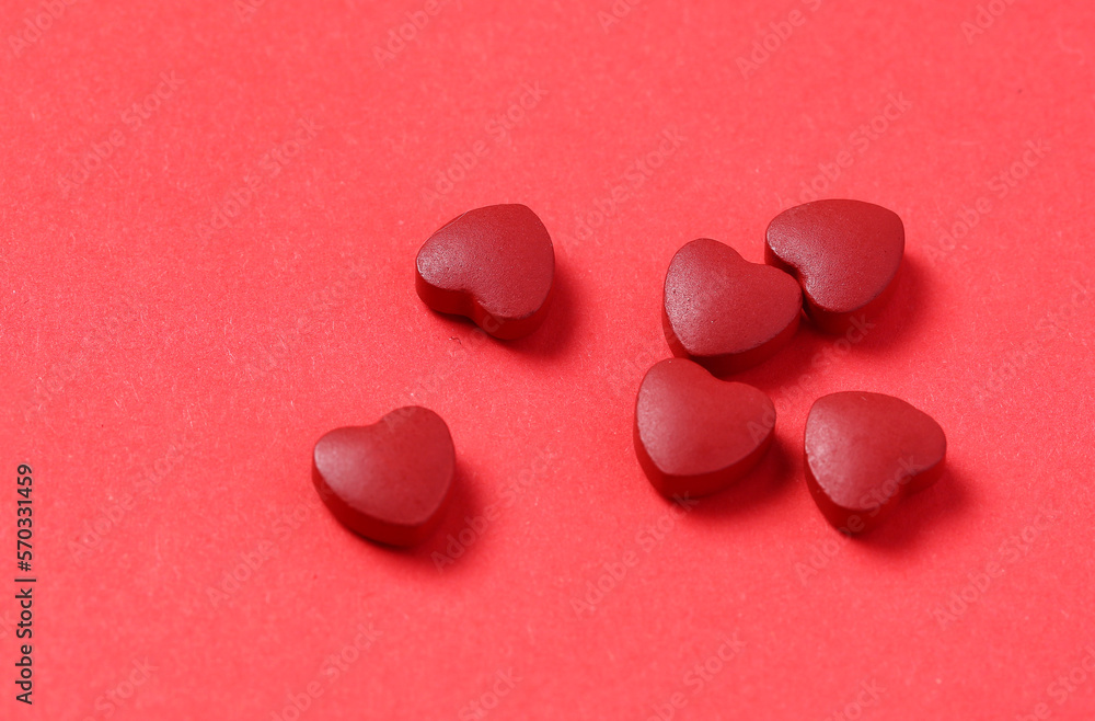 red heart-shaped coenzyme Q10 tablets placed on a red background red heart-shaped coenzyme Q10 tablets placed on a red background