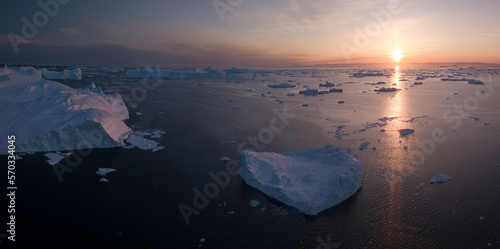 sunset on the icefjord in ilulissat drone shot of melting icebergs in greenland photo