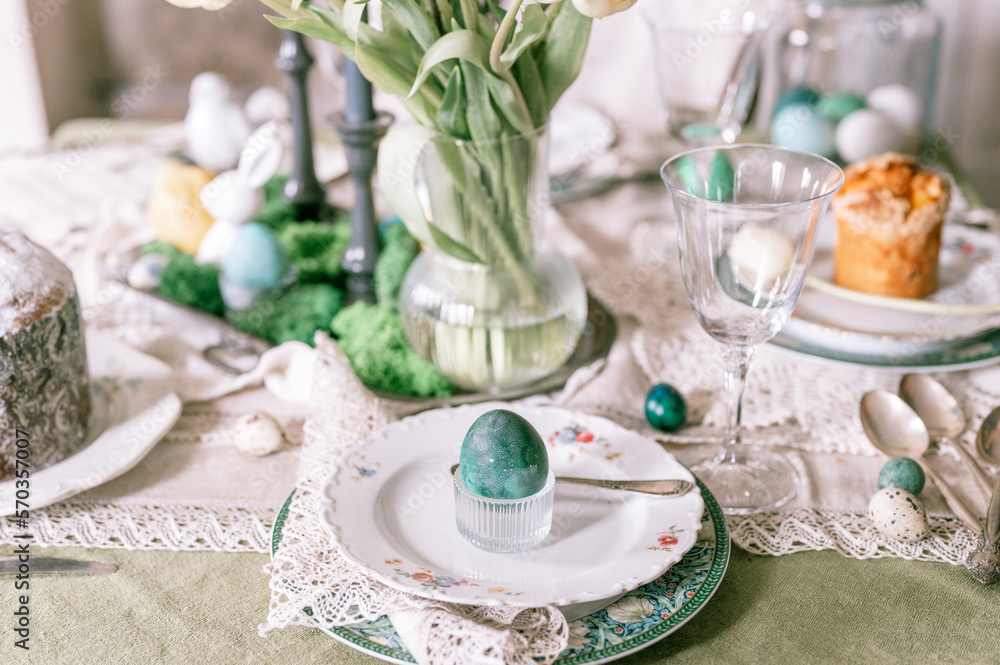 happy easter holiday in springtime season. painted green emerald colored chicken egg in bowl and plate on table. festive home decor. traditional food. sophisticated country rustic tablescape style happy easter holiday in springtime season. painted green emerald colored chicken egg in bowl and plate on table. festive home decor. traditional food. sophisticated country rustic tablescape style