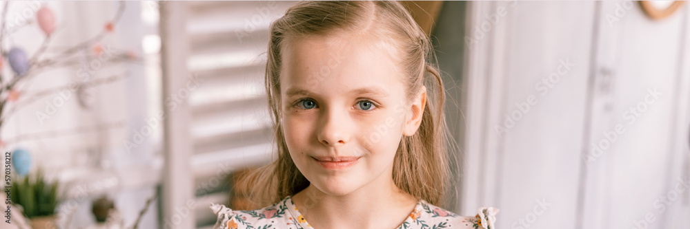 portrait face little eight year old kid girl in happy easter holiday time in spring season in home. cute candid smiling caucasian children people. festive home decor. banner