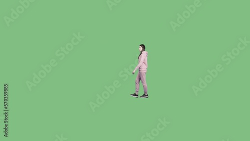 A young woman in a sportive pink suit walks slowly. Alpha channel background