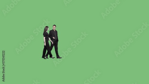 A man and a young woman in a black suit walk slowly and talk