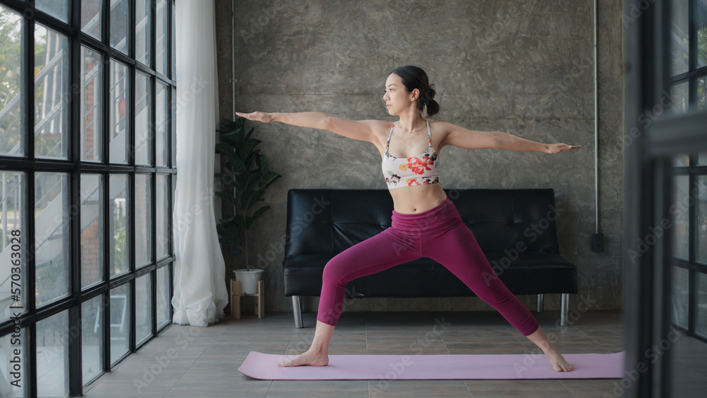 Young asian woman doing yoga in living room, yoga poses for exercise and meditation, doing yoga postures for body and mind balance, exercise for a healthy body. Yoga concept. Young asian woman doing yoga in living room, yoga poses for exercise and meditation, doing yoga postures for body and mind balance, exercise for a healthy body. Yoga concept.