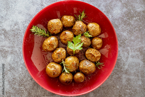 Fried (baked) whole small potatoes with rosemary and salt in a frying pan, ruddy crust, appetizing food