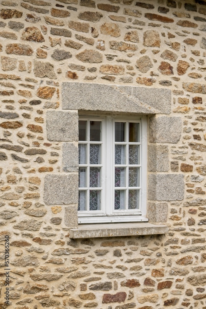Antique casement window set in stone wall granite block quions