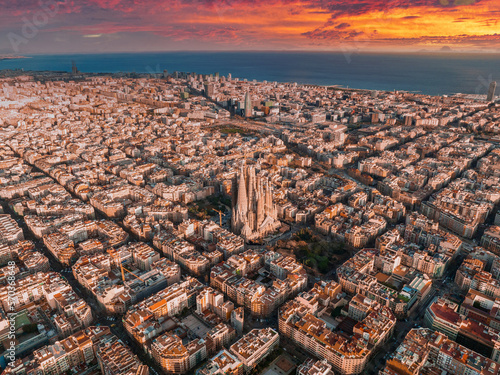 Aerial view of Barcelona City Skyline and Sagrada Familia Cathedral at sunset. Eixample residential famous urban grid. Cityscape with typical urban octagon blocks photo