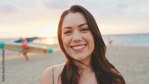 Young woman opens her eyes and smiles at the camera while standing on the beach © Andrii Nekrasov