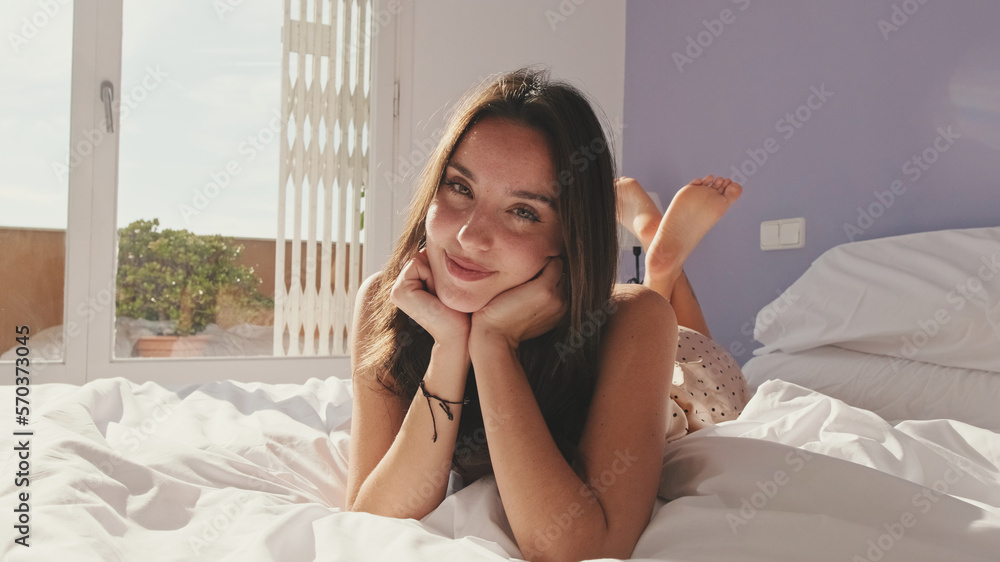 Close-up, happy girl posing lying in bed Close-up, happy girl posing lying in bed