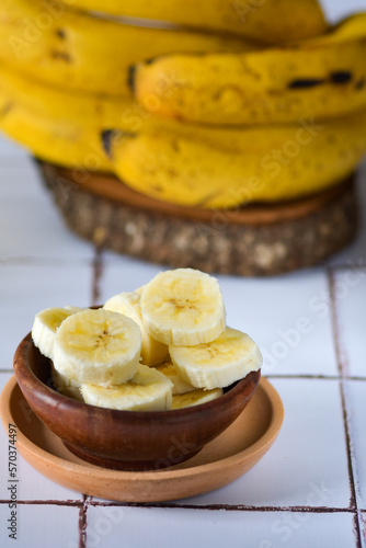 banana madura fatiada com penca de bananas ao fundo. foco seletivo photo