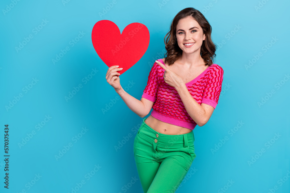 Photo of positive pretty lady hold red paper card demonstrate cardiology clinic service empty space isolated on blue color background Photo of positive pretty lady hold red paper card demonstrate cardiology clinic service empty space isolated on blue color background