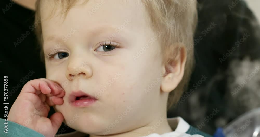 Portrait of a child, the baby is put on a mask for inhaling the medicine, the child takes off the mask and scratches his nose. Portrait of a child, the baby is put on a mask for inhaling the medicine, the child takes off the mask and scratches his nose.