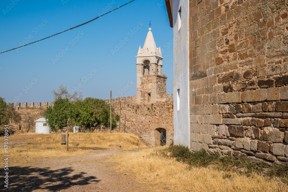 Pathway with dry herbs next to a stone wall and tower inside the castle of Mourão, Alentejo PORTUGAL